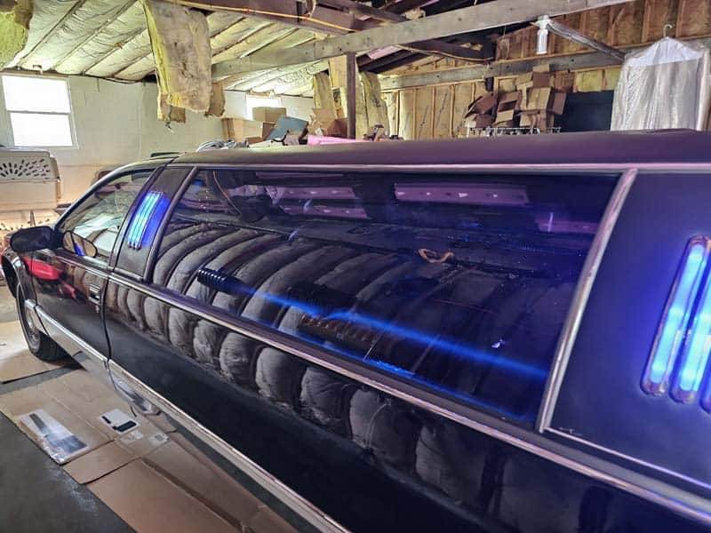 Black stretch limousine with blue interior lights indoors