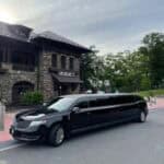 Black stretch limousine parked outside stone building
