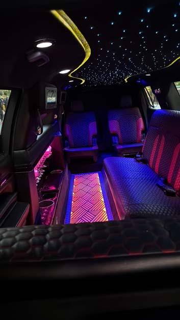 Luxury limo interior with starlight ceiling and neon lighting.