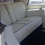 White leather bench seat inside classic boat cabin