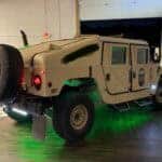 Tan Humvee with green underglow inside garage