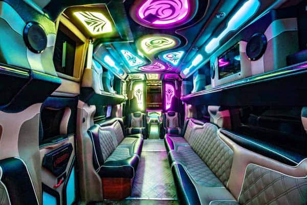 Neon-lit luxury party bus interior with leather seating