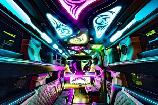 Neon-lit luxury limousine interior with colorful LED ceiling