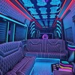 Neon-lit luxury party bus interior with leather seating