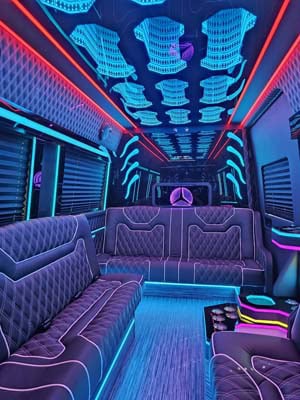 Neon-lit luxury party bus interior with leather seating