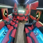 Luxury party bus interior with red seating and blue lighting