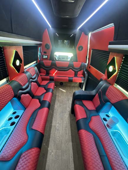 Luxury party bus interior with red seating and blue lighting