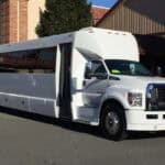 White stretch limousine bus parked outside building