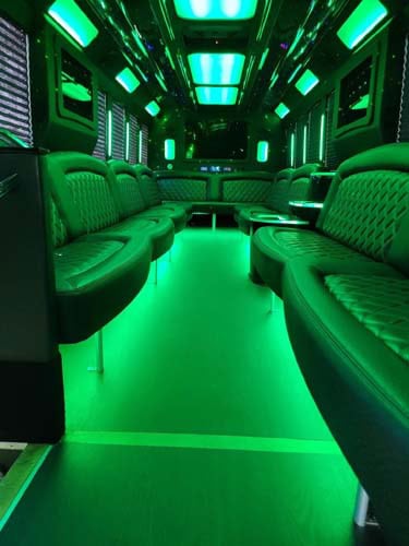 Green neon-lit luxury party bus interior seating