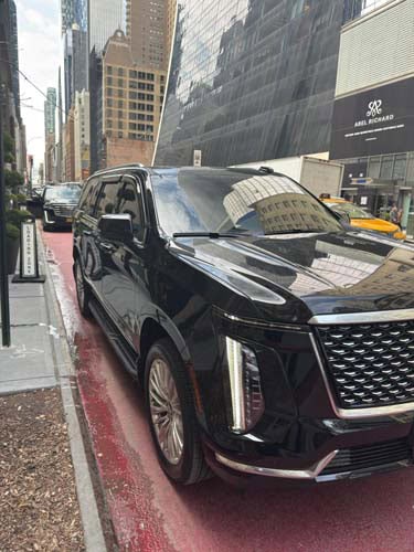 Black luxury SUV parked on city street