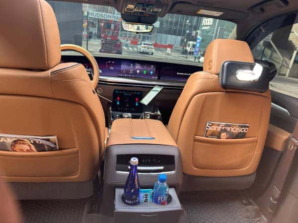 Luxury car interior with tan leather seats and city view