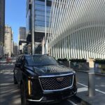 Black Cadillac Escalade in NYC with Oculus and skyscrapers.