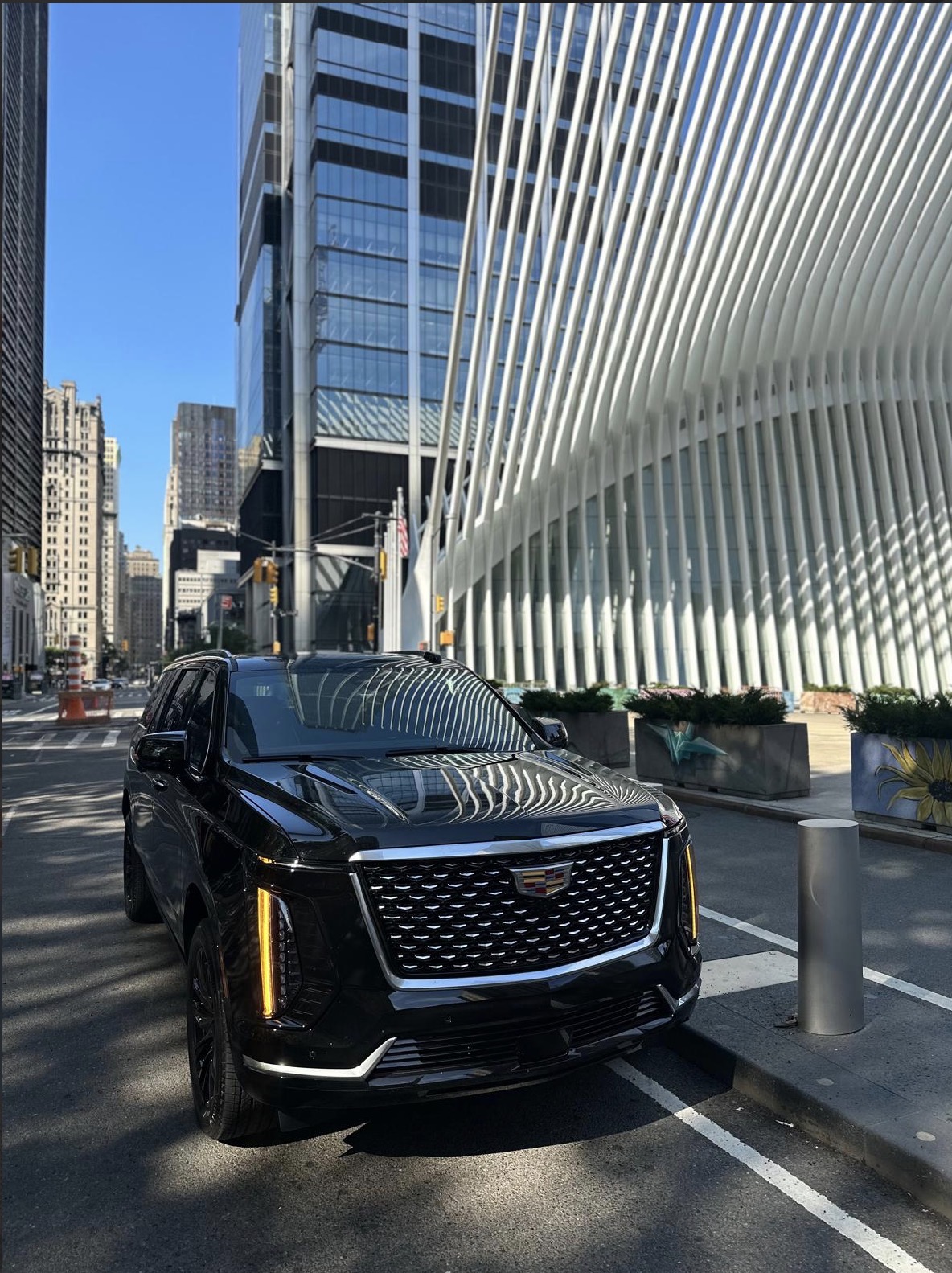 Black Cadillac Escalade in NYC with Oculus and skyscrapers.