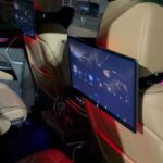 Luxury car rear seats with dual entertainment screens at night