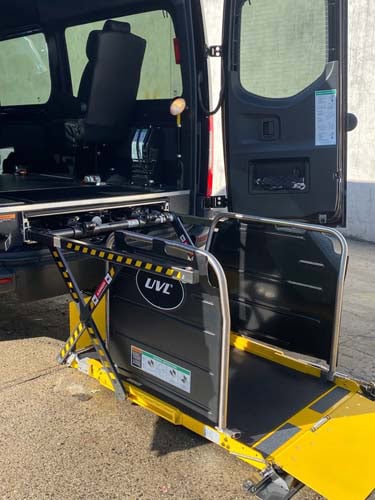 Van with deployed wheelchair lift platform at rear