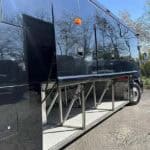 Luxury bus with extended undercarriage storage compartments open