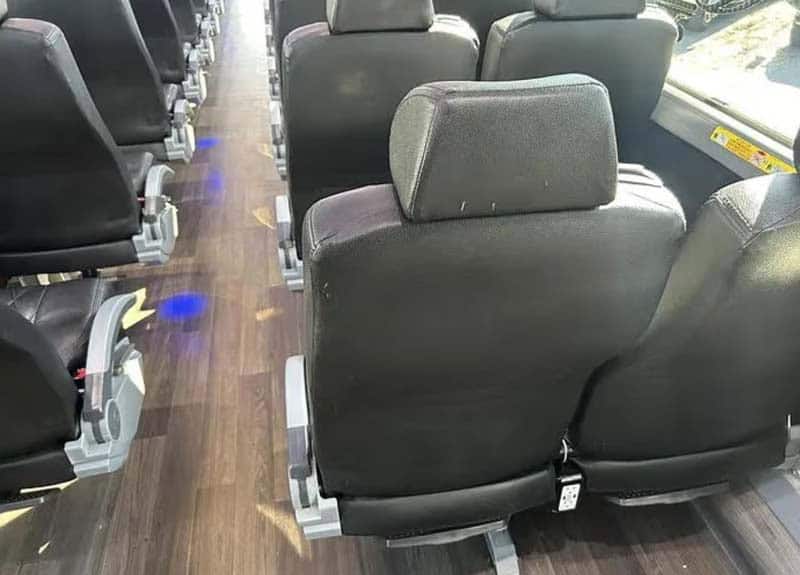 Interior of bus with black seats and aisle