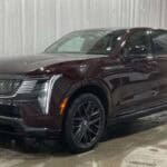 Dark maroon Cadillac SUV in indoor showroom