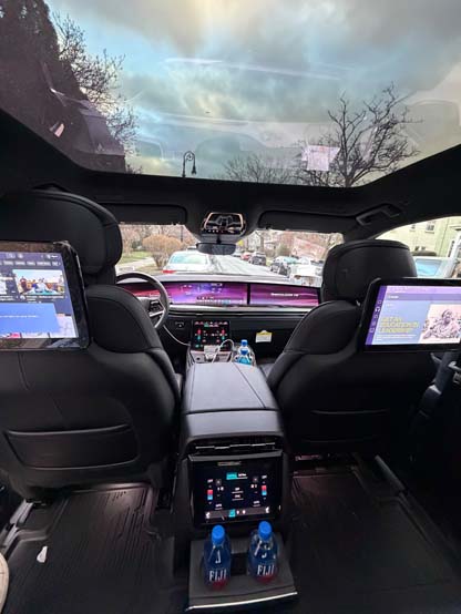 Luxury car interior with rear entertainment screens and panoramic sunroof