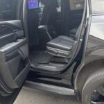 Open rear door of black luxury SUV with leather seats