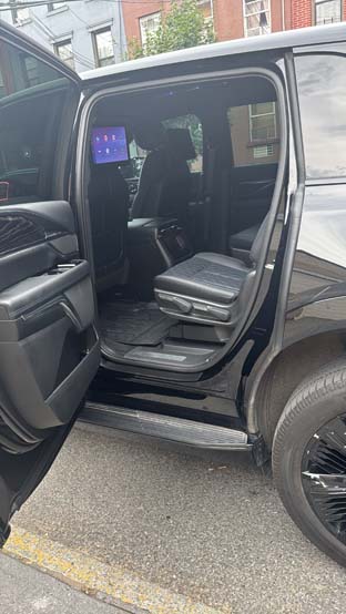 Open rear door of black luxury SUV with leather seats