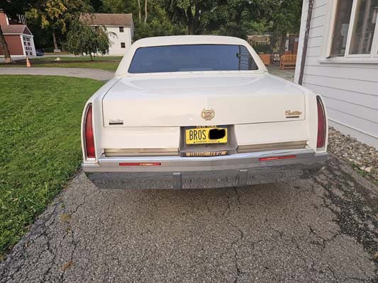 Rear view of white Cadillac sedan parked driveway