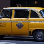 Vintage yellow taxi cab parked on city street
