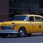 Vintage yellow taxi cab parked on city street