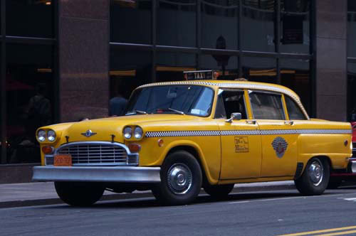 Vintage yellow taxi cab parked on city street
