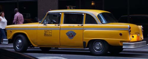 Vintage yellow taxi cab parked on city street