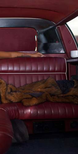 Person lounging on red leather car backseat