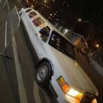 White stretch limousine parked on city street at night
