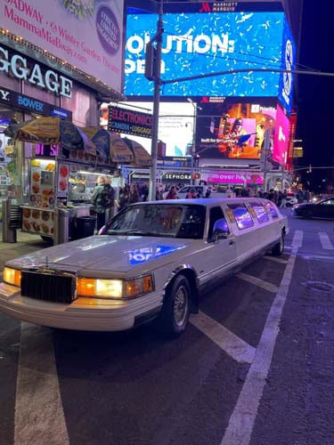 White stretch limousine in Times Square at night