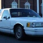 White stretch limousine parked outside brick building