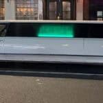 White stretch limousine parked on city street at night