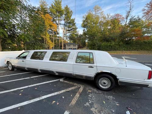 Long white stretch limousine parked in lot