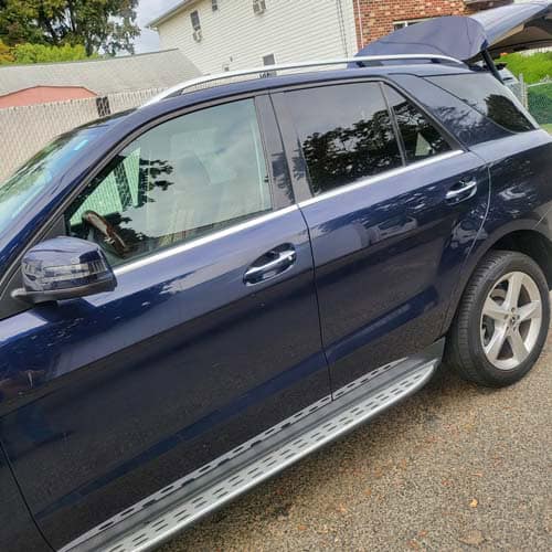 Blue SUV parked in driveway with rear hatch open
