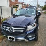 Dark blue Mercedes-Benz SUV parked on residential street