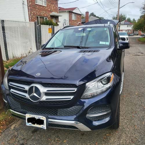 Dark blue Mercedes-Benz SUV parked on residential street