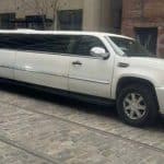 White stretch SUV limousine on cobblestone street