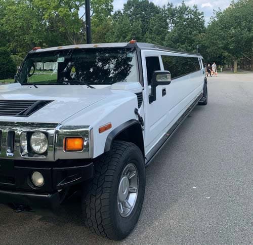 White stretch Hummer limousine parked on road