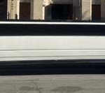 White stretch limousine parked on city street