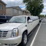 White Cadillac Escalade stretch limousine parked on city street
