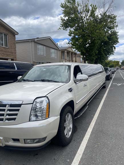 White Cadillac Escalade stretch limousine parked on city street