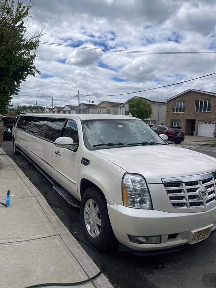 White Cadillac Escalade stretch limousine parked on residential street