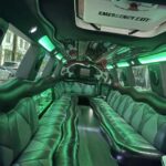 Luxury stretch limousine interior with green LED lighting and leather seats