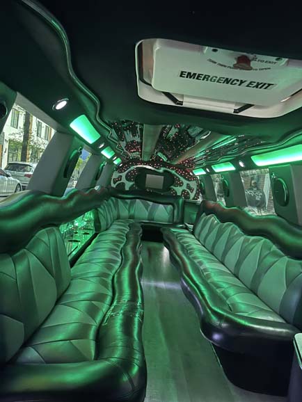 Luxury stretch limousine interior with green LED lighting and leather seats
