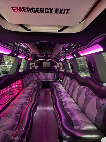 Luxury limousine interior with pink LED lighting and leather seats