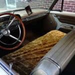 Vintage car interior with bench seats and classic steering wheel