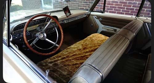 Vintage car interior with bench seats and classic steering wheel